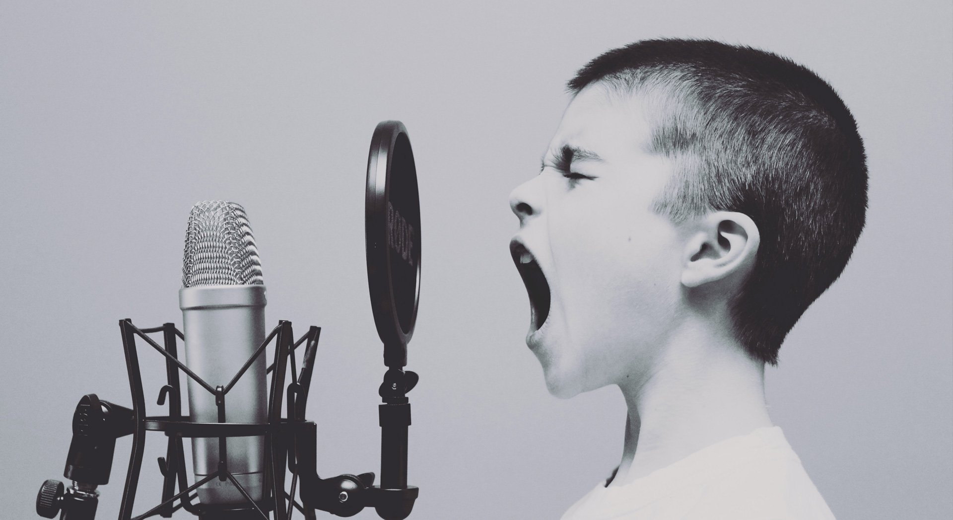 Niño gritando a través de un micrófono